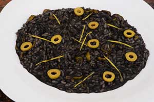 Risotto al nero di seppia con olive profumato al limone